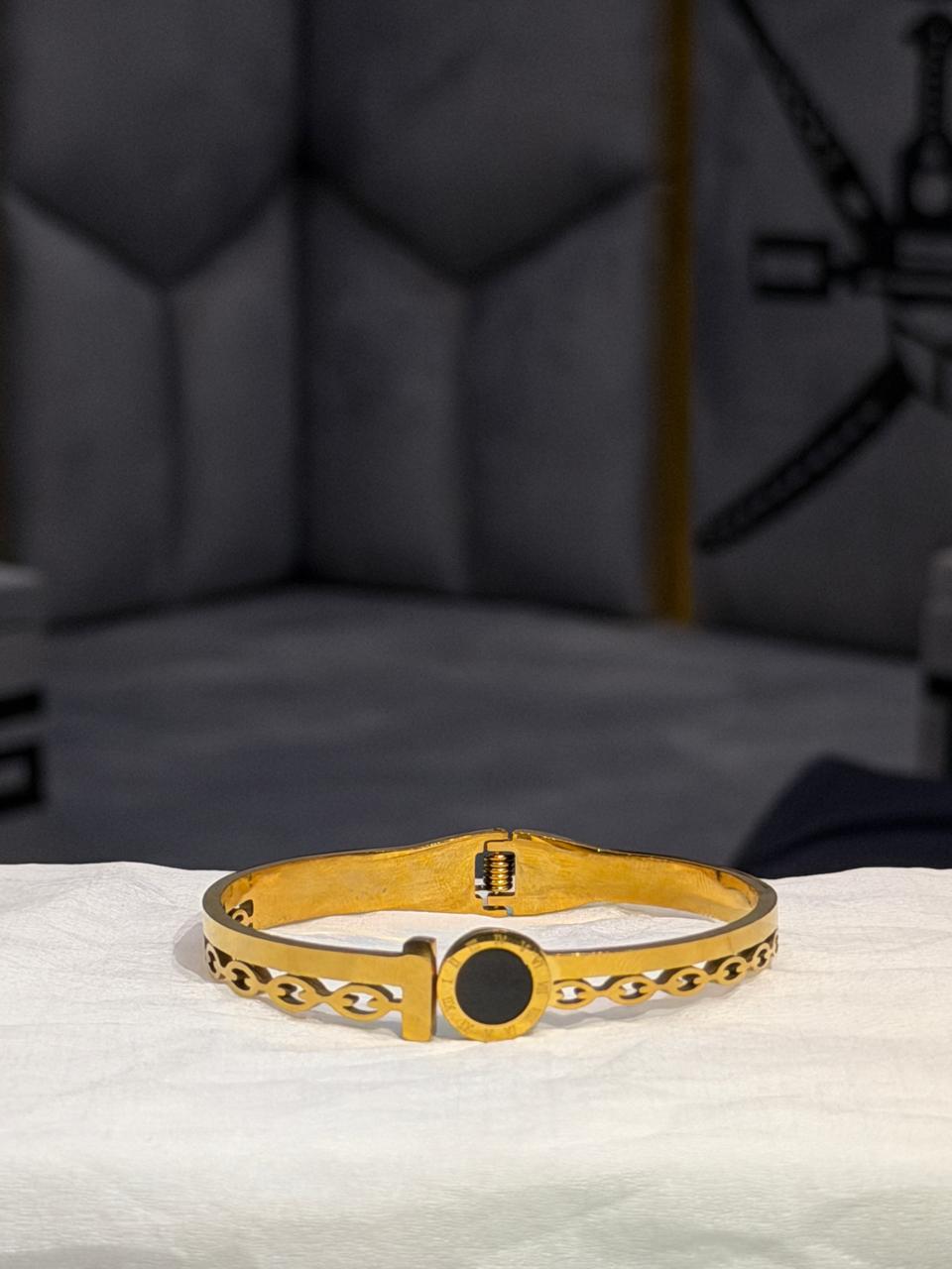 Gold hinged bangle with onyx accent